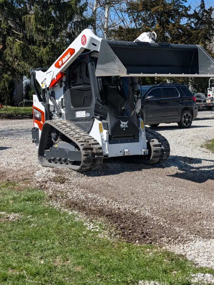 Bobcat loader positioned on a gravel drive ready for site work